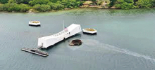The USS Arizona Memorial is shown from an aerial shot as it respectfully rests over the sunken battleship. Around 1,177 of her crewmen were killed with the majority still entombed within this ship. Over 2,400 Americans were killed in the unprovoked attack