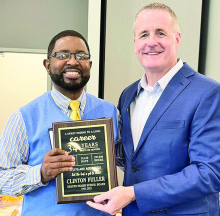 Clinton Fuller receives an award from Superintendent Clay Corley honoring his retirement after 34 years of dedicated service.
