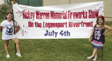 How it all began! Bentley and Keleigh Warren hold up the original banner of the First Rickey Warren Memorial Fireworks show. It has been renamed the Warren Family Fourth of July Festival. The little girls are now teenagers.