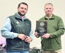 Chief Deputy Raymond Sharrow (on right) displays a commemorative plaque that Sheriff Jayson Richardson presented to him for his retirement.